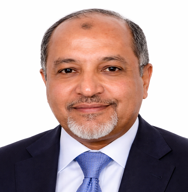 Head-and-shoulders portrait of a smiling man in a navy suit and blue tie against a white background.