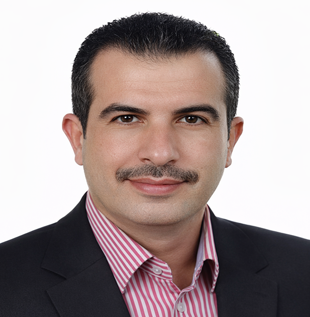 Professional headshot of a man in a dark suit and pink striped shirt, looking at the camera with a neutral background, suitable for a business profile.
