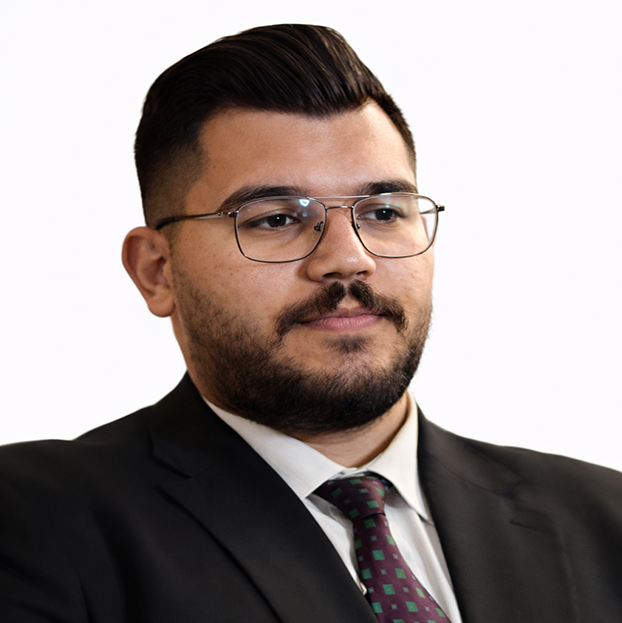 Portrait of a man in a black suit and tie wearing glasses, looking slightly to the right.