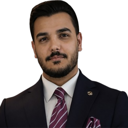 Professional portrait of a man with dark hair and a trimmed beard, wearing a navy suit, white shirt, and maroon striped tie.