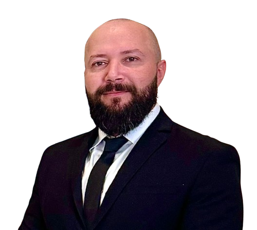 Professional headshot of a bald man with a full beard wearing a black suit and tie.