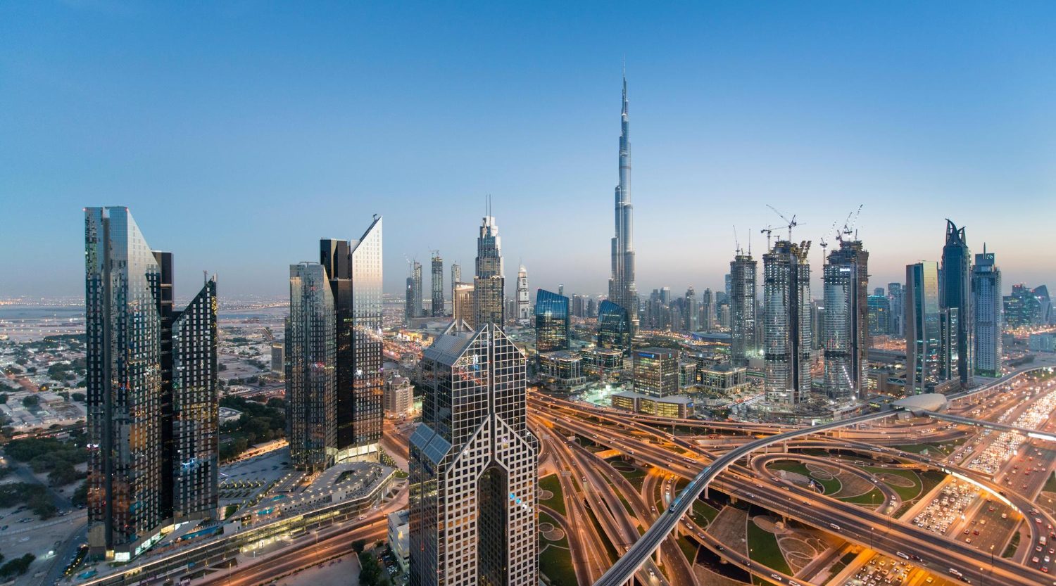 Aerial view of Dubai's skyline featuring the Burj Khalifa and intersecting highways beneath.