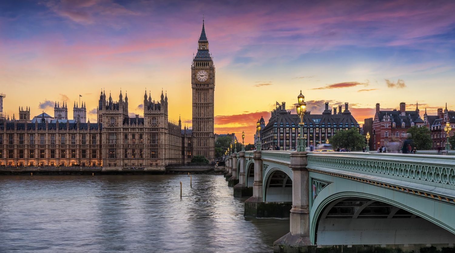 Sunset over the Thames with Big Ben and the Houses of Parliament beside Westminster Bridge in London.